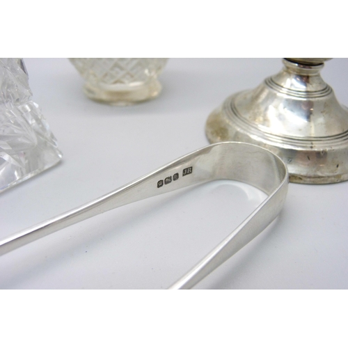 835 - Two pairs of silver sugar bows, a silver candlestick, a sterling sifter spoon and other silver mount... 