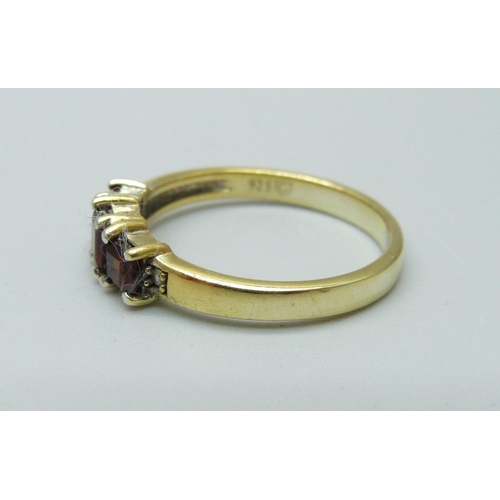 911 - A silver gilt and garnet three stone ring, P/Q