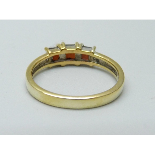 911 - A silver gilt and garnet three stone ring, P/Q