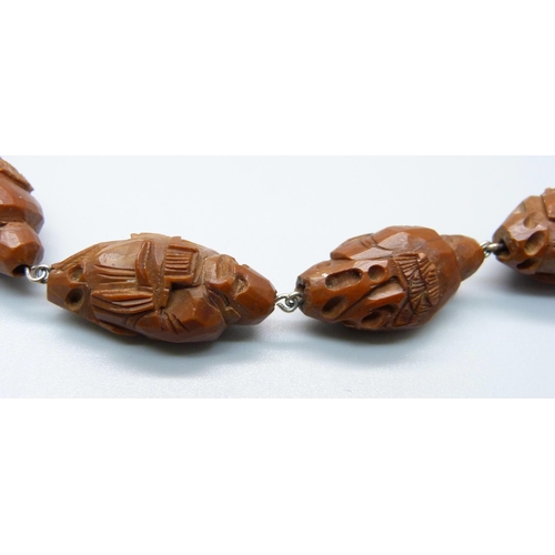 987 - A vintage carved wood necklace depicting eastern deities