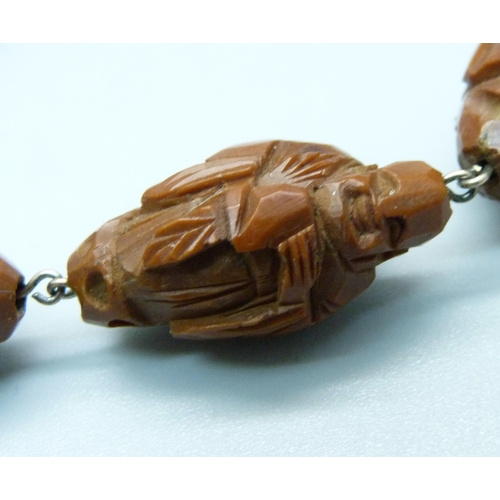 987 - A vintage carved wood necklace depicting eastern deities