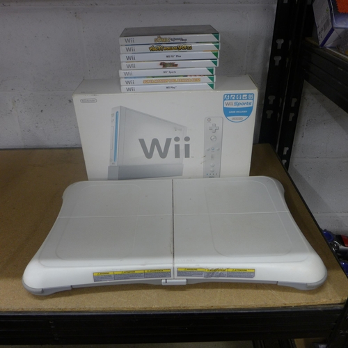 2097 - A Wii console with balance board and 7 games box