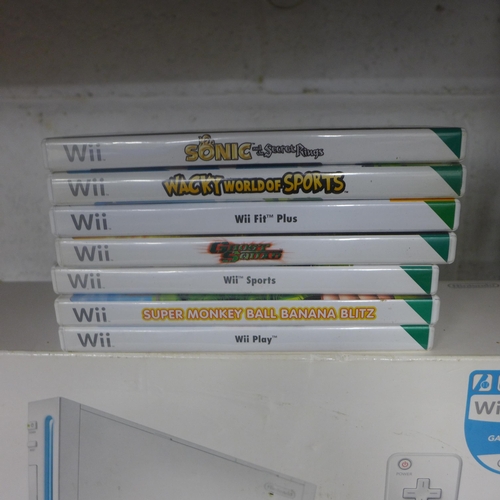 2097 - A Wii console with balance board and 7 games box