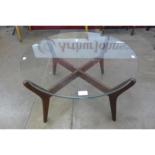 11 - A teak and glass topped circular coffee table