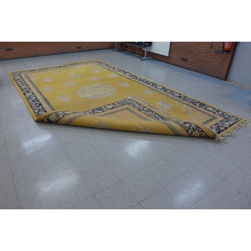 157 - A large Chinese mustard ground rug, 280 x 500cms