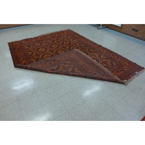 161 - An eastern terracotta ground rug, 258 x 355cms