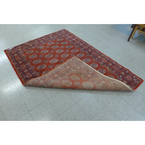 163 - A Belgian red ground rug, 180 x 241cms