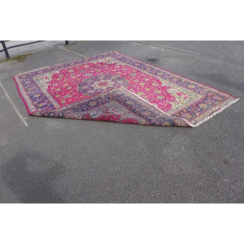 164 - A large Persian red ground rug, 306 x 406cms