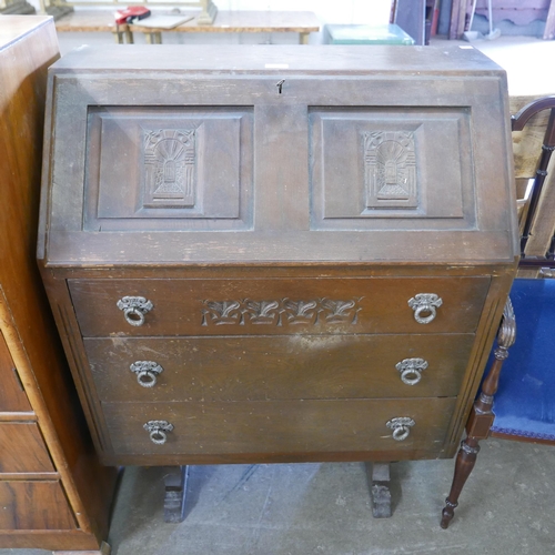 203 - An Art Deco walnut tallboy and a carved oak bureau