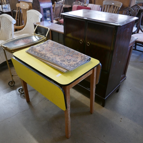 209 - A teak bookcase, a Stag Minstrel mahogany tallboy, a brass two tier drinks trolley and a rug