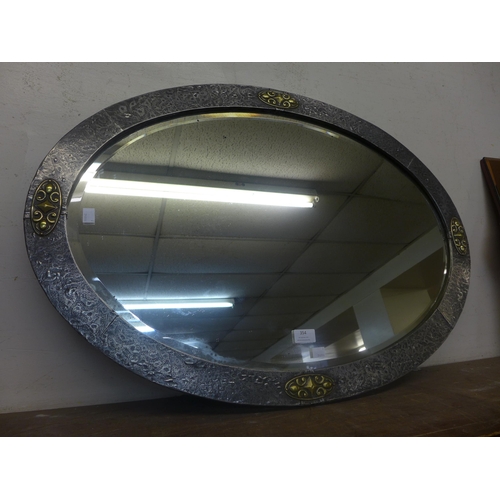 354 - An Arts and Crafts pewter and brass oval framed mirror