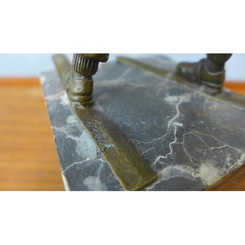 358 - A bronze figure of a young boy on skis, on grey marble socle