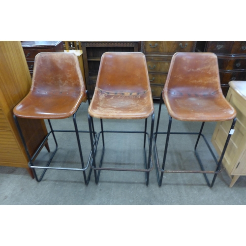 57 - A set of three brown leather and black tubular metal bar stools