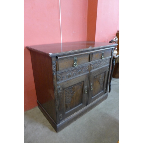 97 - A German Jugenstil carved oak sideboard with marble brushing slide