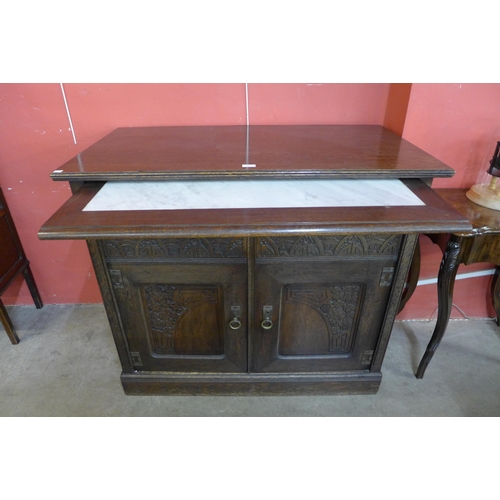 97 - A German Jugenstil carved oak sideboard with marble brushing slide