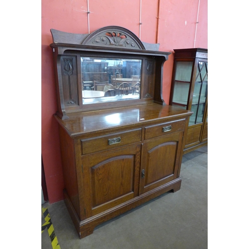 99 - An Arts and Crafts carved oak mirrorback sideboard