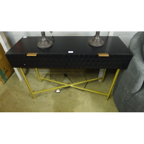 1440 - A black console table with gold legs