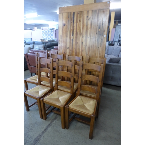 1521 - A large rustic dining table and eight oak ladderback chairs