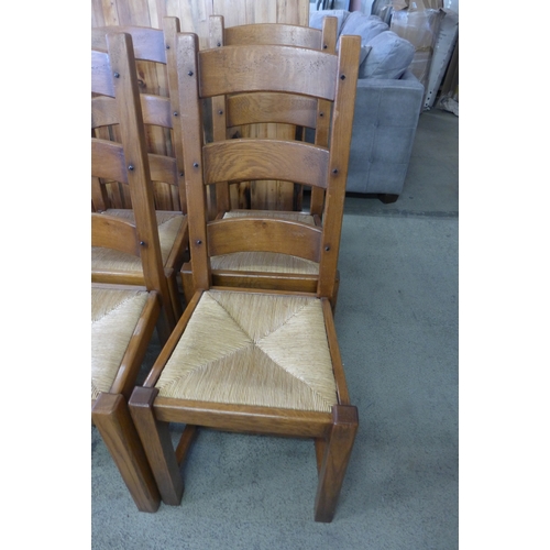 1521 - A large rustic dining table and eight oak ladderback chairs