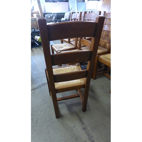 1521 - A large rustic dining table and eight oak ladderback chairs