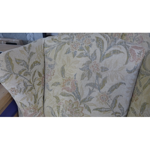 1548 - A Multiyork cream floral upholstered three seater sofa and a pair of matching armchairs