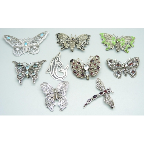 1030 - Nine large silver brooches; seven butterfly, one dragonfly and one whale, three set with garnets and... 