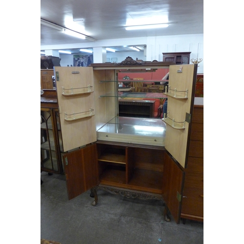 100 - A Queen Anne style figured walnut cocktail cabinet