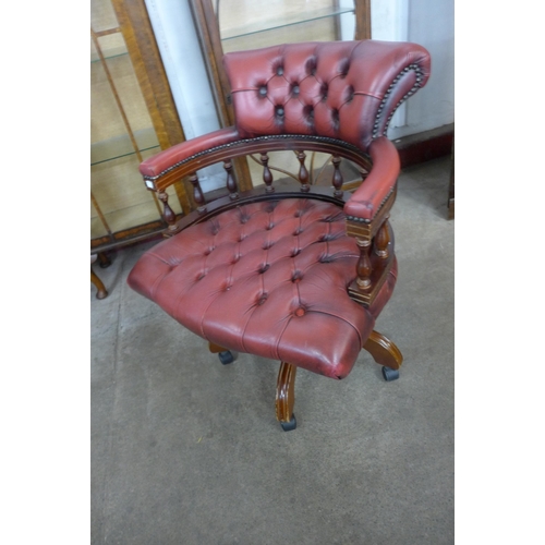 101 - A mahogany and oxblood red leather revolving Captain's desk chair