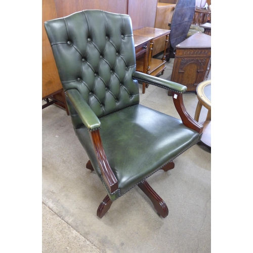 120 - A mahogany and green leather revolving desk chair