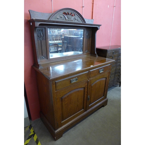 162 - An Arts and Crafts carved oak mirrorback sideboard