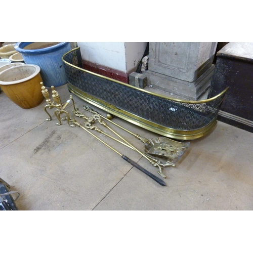 263 - A Victorian pierced brass fender, a pair of brass andirons and companion set