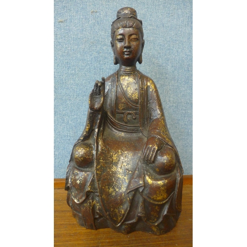 335 - An oriental faux bronze figure of a seated deity