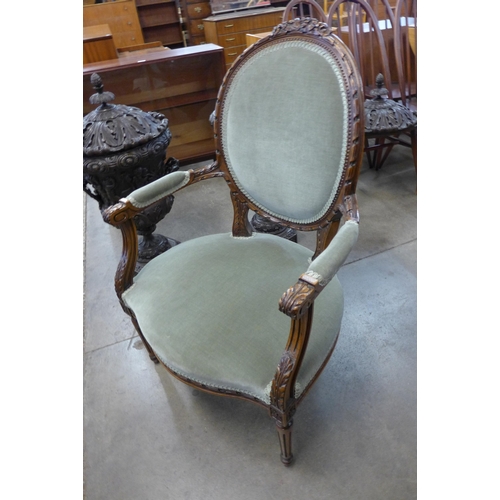 76 - A French Louis XV style carved walnut and green fabric upholstered fauteuil chair