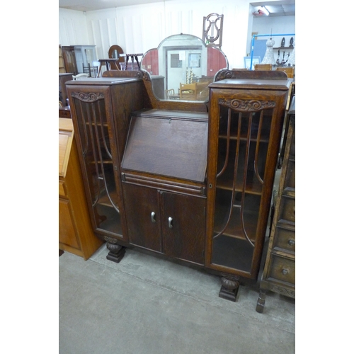 95 - An early 20th Century carved oak side by side bureau bookcase