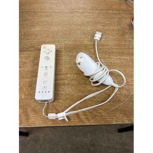 2122 - A Nintendo Wii with controller, joystick, Wii board, Just Dance and Wii Fit