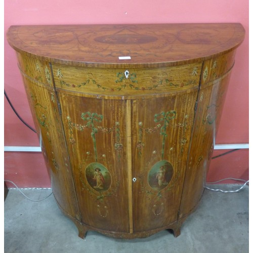 84 - An Edward VII Sheraton Revival painted satinwood demi lune side cabinet. With non-transferable Stand... 