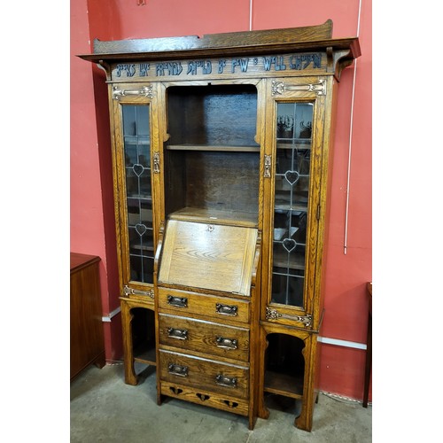 87 - An Arts and Crafts Liberty & Co. oak bureau bookcase, with inscription; Books Like Friends Should Be... 