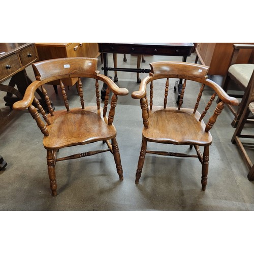 92 - A pair of Victorian style elm and beech smokers bow chairs