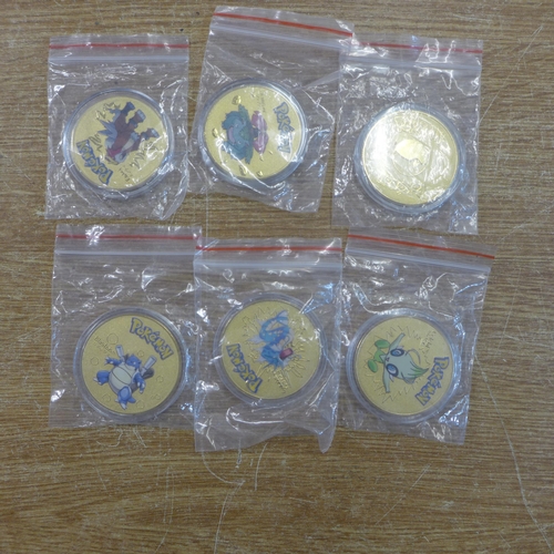 2147 - A selection of Pokemon collector items including:- 6 gold coloured coins, pair of socks, watch, card... 