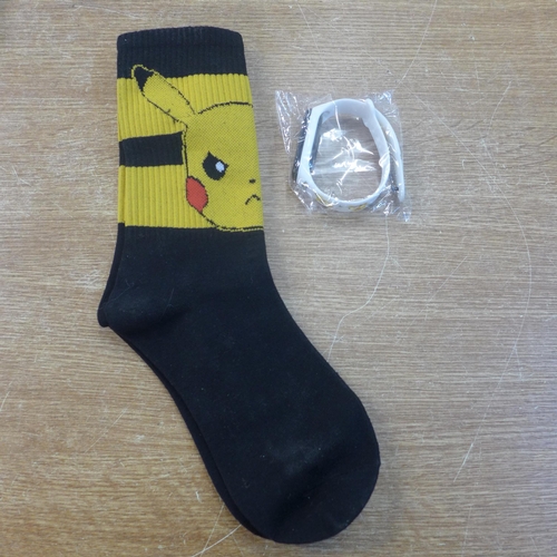 2147 - A selection of Pokemon collector items including:- 6 gold coloured coins, pair of socks, watch, card... 