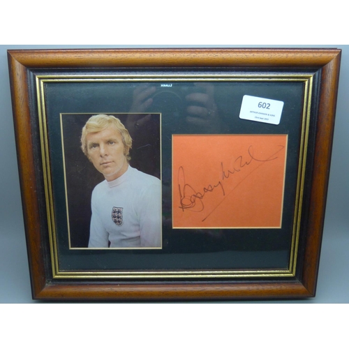 602 - Two framed and mounted photographs and signatures - Matt Busby and Bobby Moore