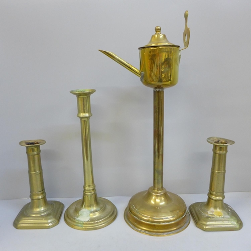 720 - A Georgian brass whale oil lamp, a pair of gun barrel candlesticks and a tall single candlestick