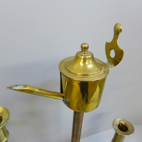 720 - A Georgian brass whale oil lamp, a pair of gun barrel candlesticks and a tall single candlestick