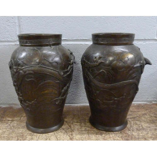 820 - A pair of Japanese Meiji bronze vases, decorated with dragons and birds, both a/f