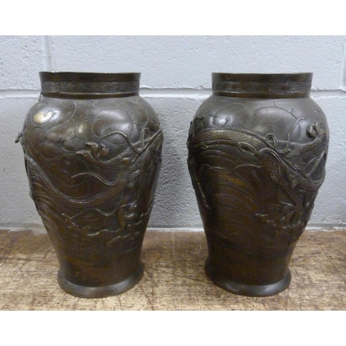 820 - A pair of Japanese Meiji bronze vases, decorated with dragons and birds, both a/f