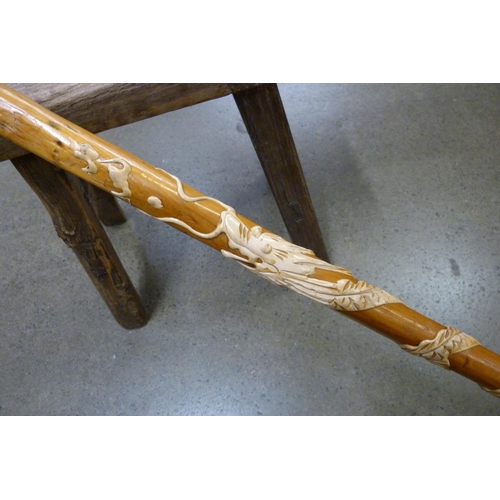 830 - A wooden stool and walking stick with dragon motif