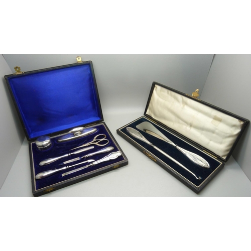 848 - A silver handled shoehorn and hook set and silver mounted manicures, (matched tweezers and scissors)