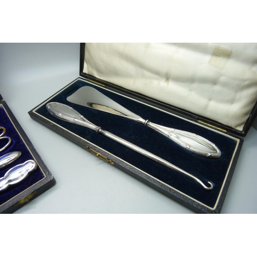 848 - A silver handled shoehorn and hook set and silver mounted manicures, (matched tweezers and scissors)