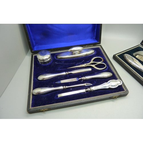 848 - A silver handled shoehorn and hook set and silver mounted manicures, (matched tweezers and scissors)