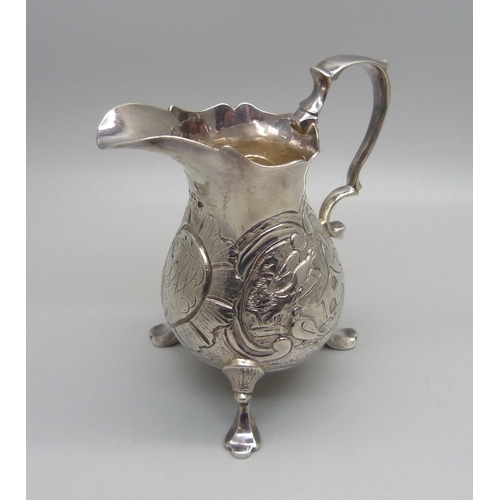 853 - A George II silver cream jug, London 1744, with pigeon and other bird detail, 101g